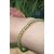Bracelet en péridot (perles 4 mm vert olive translucide), monté sur fil, porté au poignet ; photo en extérieur avec feuillage vert en arrière-plan, ambiance fraîche et lumineuse, évoque vitalité, optimisme et légèreté.