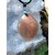 Pendentif goutte en pierre de soleil sur cordon noir, posé sur cristaux blancs et mousse, bijou en pierre naturelle associé à la chaleur intérieure, à l’élan positif et à la confiance douce.