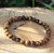 Bracelet Œil de Tigre 6 mm sur élastique, perles brun doré sur rondin de bois en décor naturel, discernement et assurance.