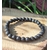Bracelet Pierre de Lave 6 mm sur élastique, perles noires poreuses sur tranche de bois avec herbes, ancrage et force intérieure.