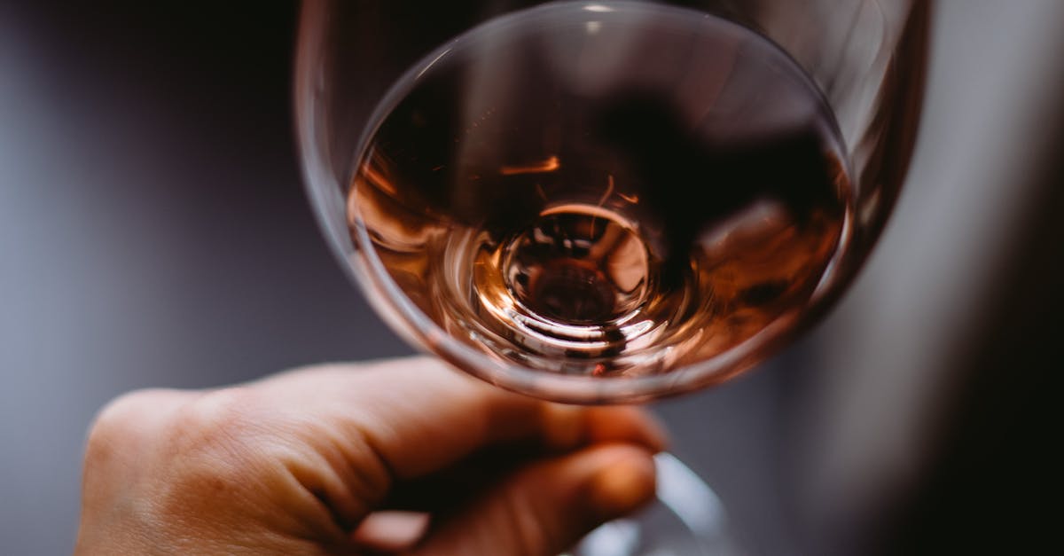 crop personne meconnaissable appreciant le vin rose parfume