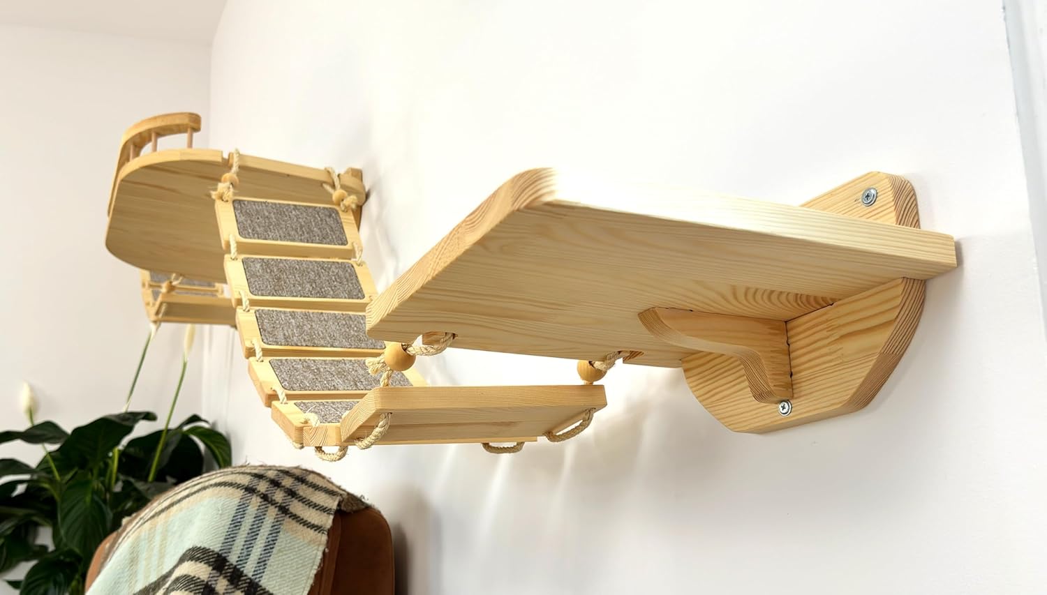 Chat explorant un mur d’escalade avec tapis doux et éléments suspendus en corde sisal.