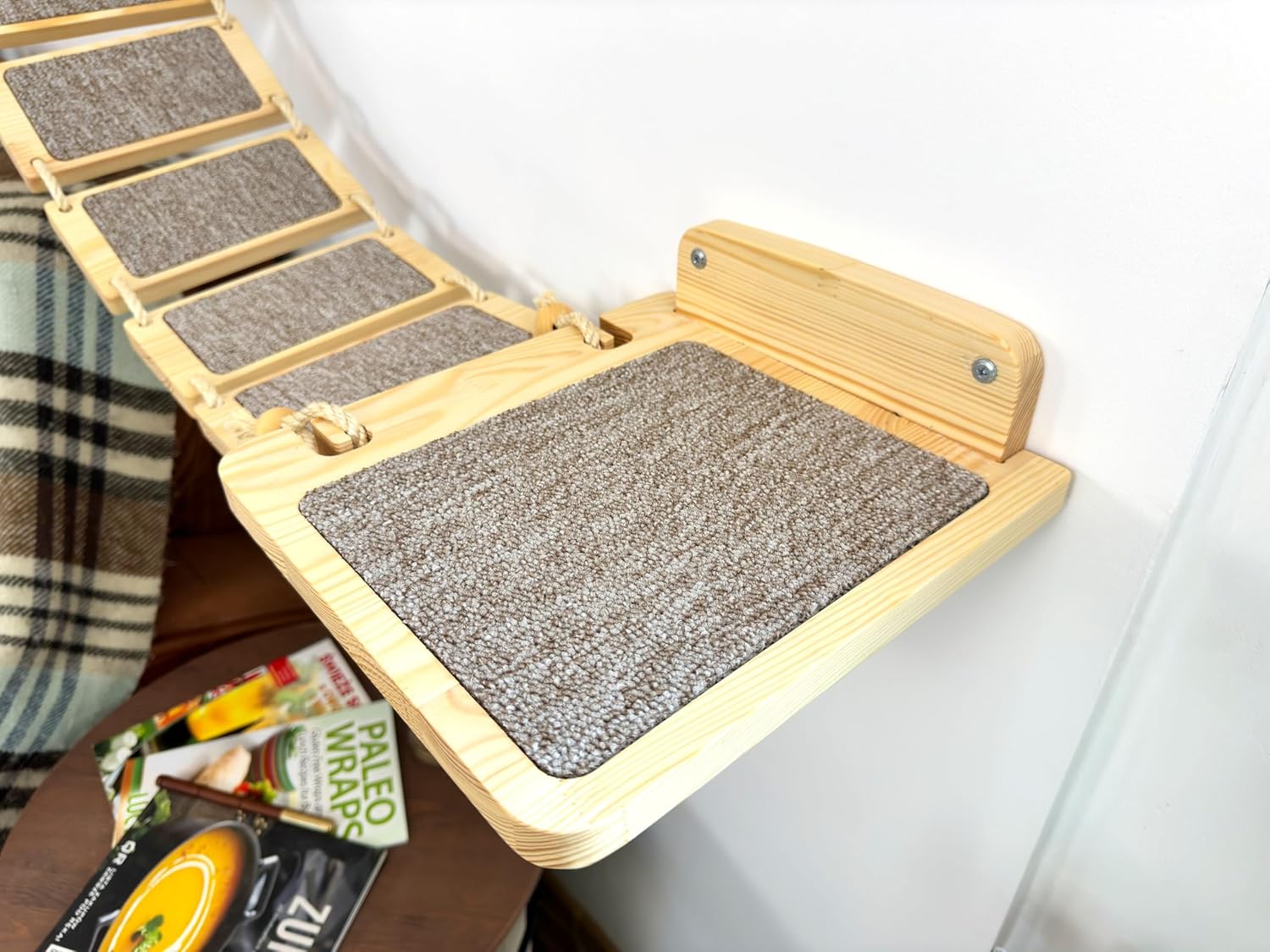 Ponts modulaires en bois pour chat, éléments suspendus et hamac avec coussin doux sur mur clair.