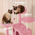 Groupe de chats explorant les plateformes et jouant sur les accessoires suspendus de l’arbre à chat