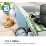 Chat mangeant des croquettes dans un bol incliné relié au distributeur connecté.