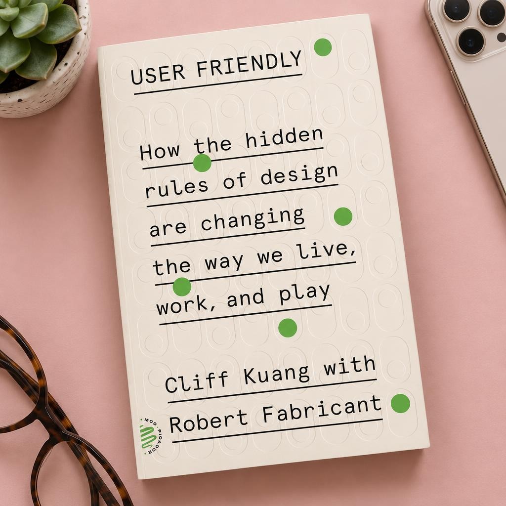 User Friendly by Cliff Kuang and Robert Fabricant on a pink desk with a phone, glasses and a succulent