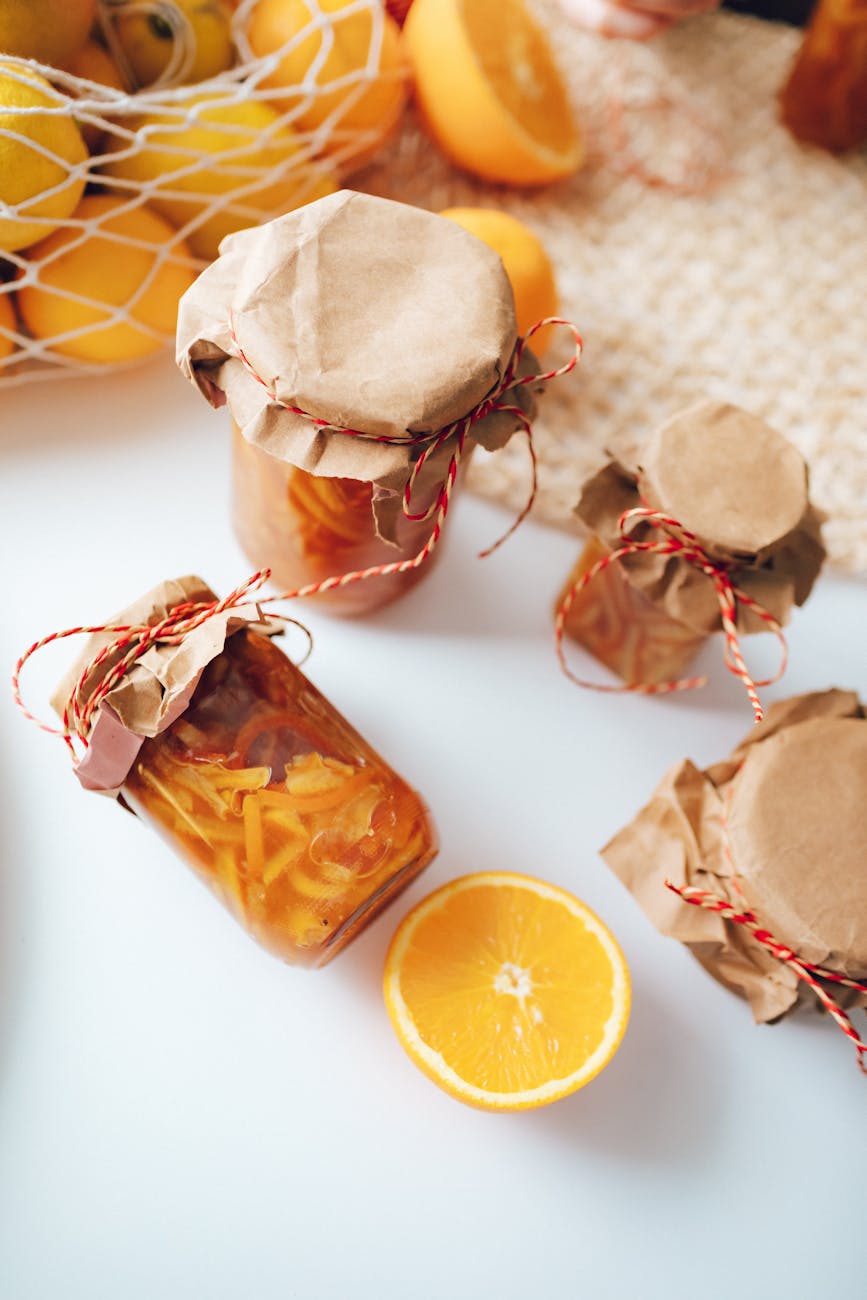 orange fruit beside clear glass jar