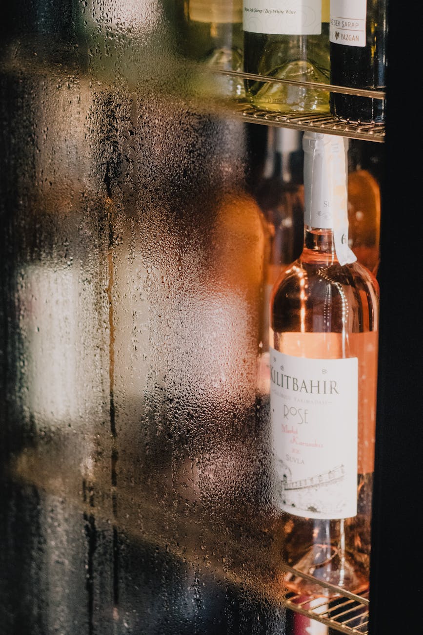 close up of wine bottles with moisture in a refrigerated display cabinet