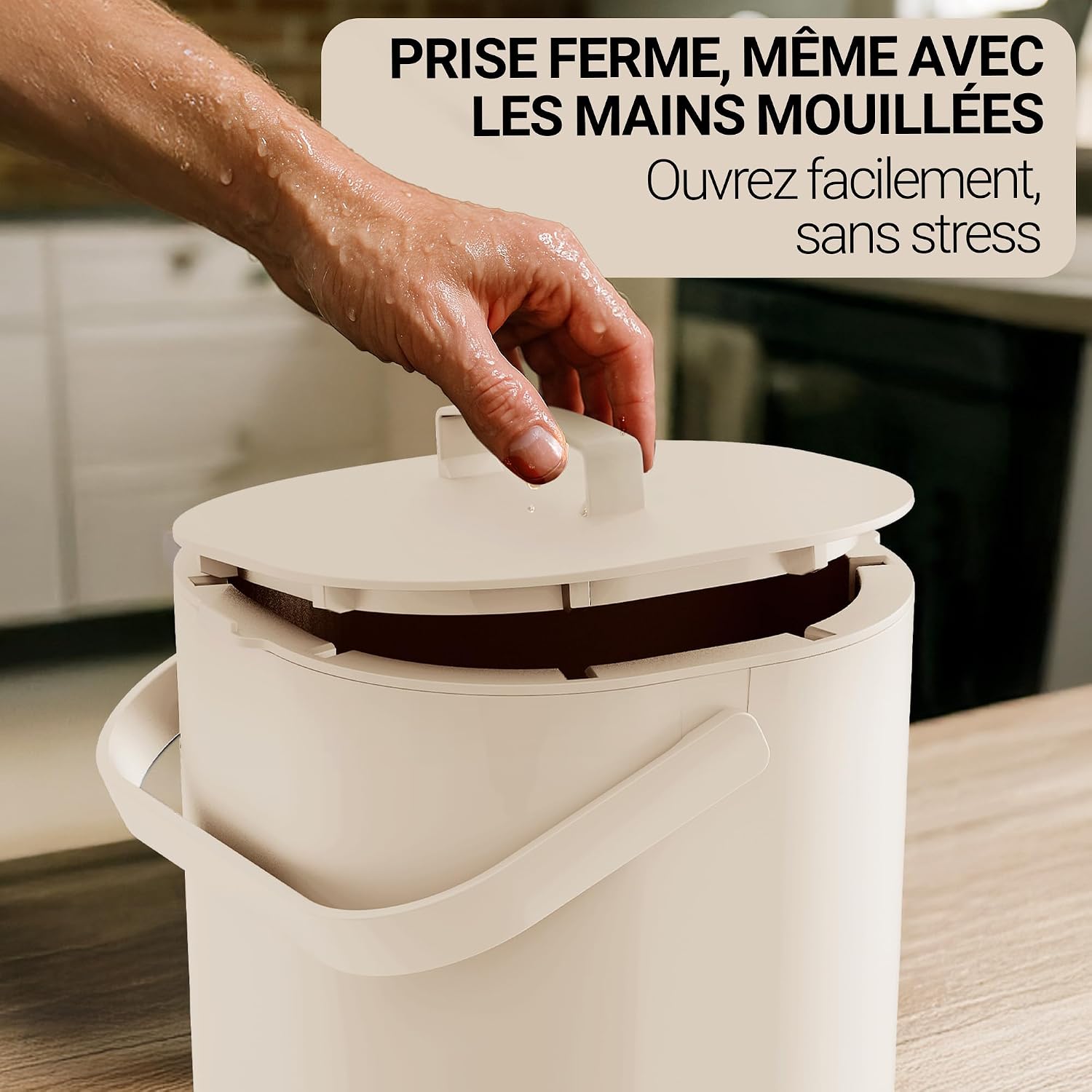 Main ouvrant le couvercle du seau beige dune seule main, près dun plan de travail