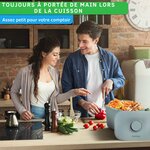 Couple cuisinant des légumes avec le seau à compost YourCasa sur le plan de travail