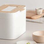 Seau blanc à couvercle en bambou, près dune planche et dun bol en bois