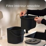 Mains retirant le filtre intérieur amovible du seau à compost noir