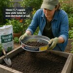 Jardinière tamisant de la terre au-dessus dun carré potager en bois