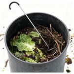 Aérateur planté dans un bac à compost rempli de feuilles de salade et de branchages