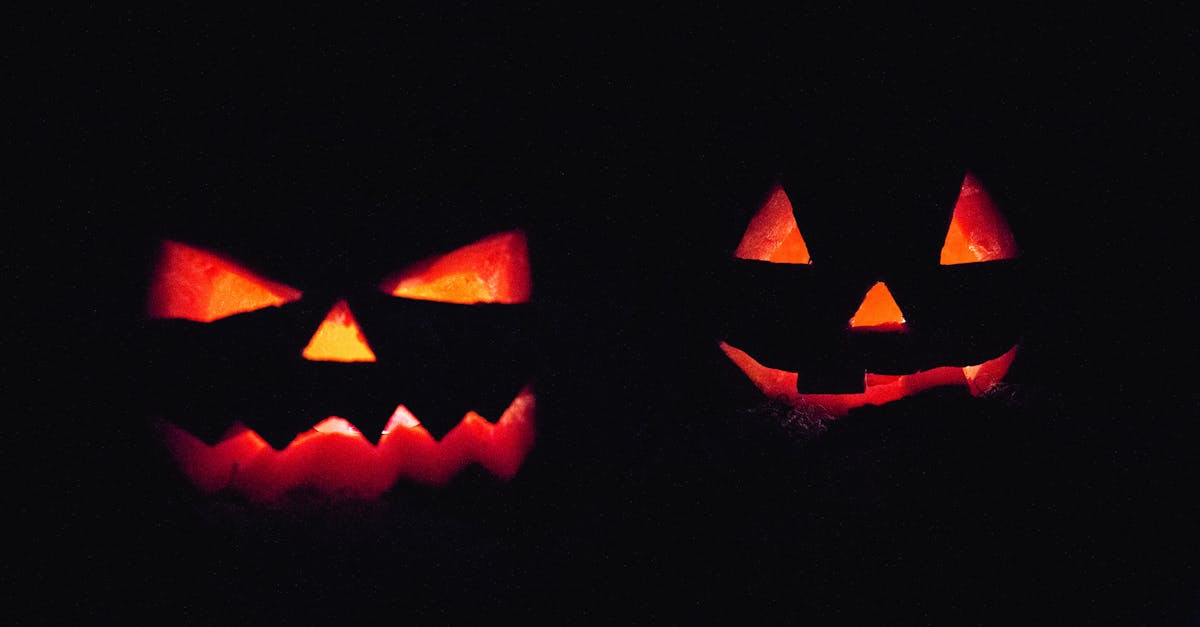 two illuminated jack o lanterns in dark creating an eerie halloween atmosphere