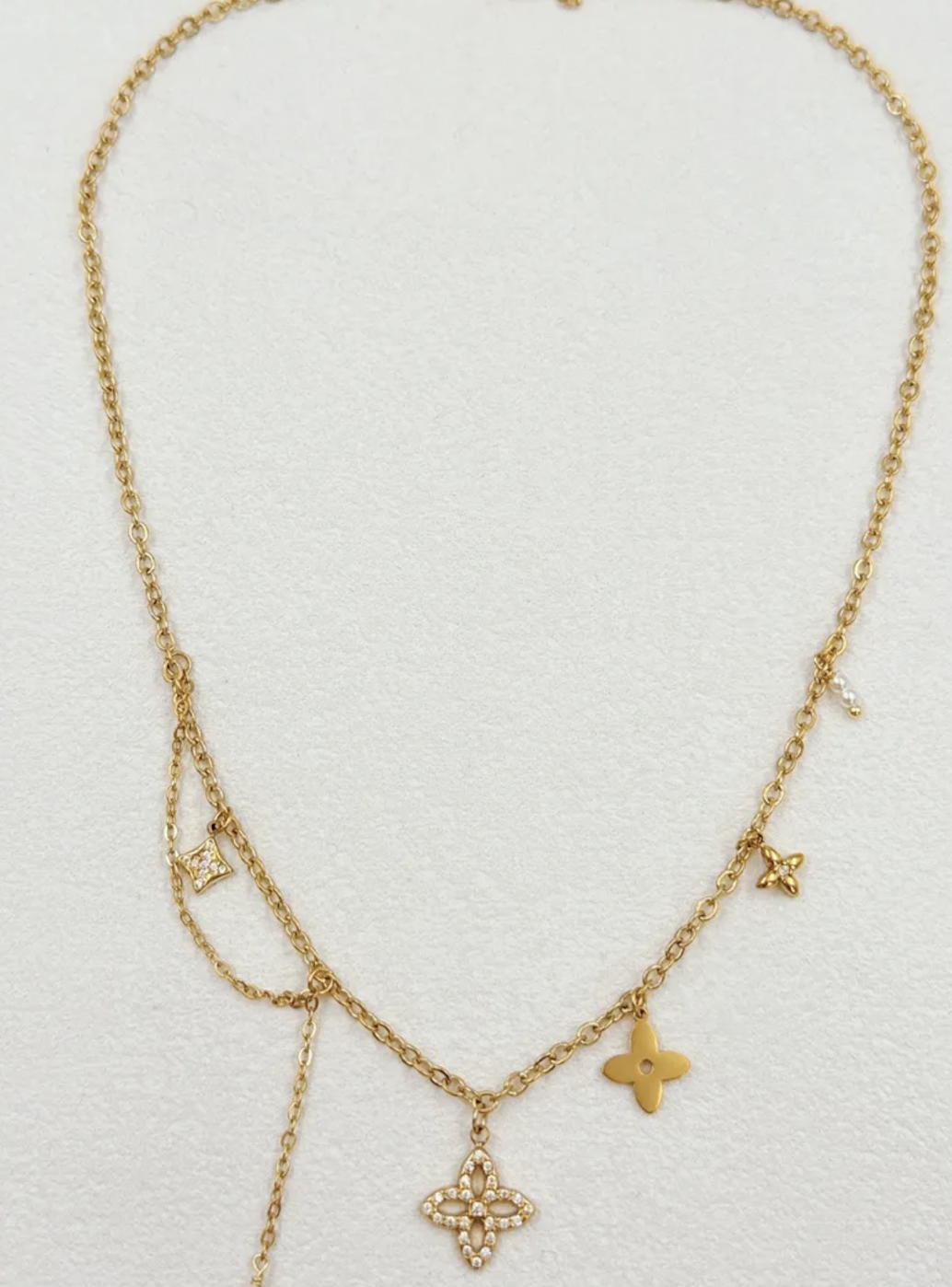 Collier Bellagio : Motifs floraux, détails clairs et chaîne asymétrique avec partie pendante