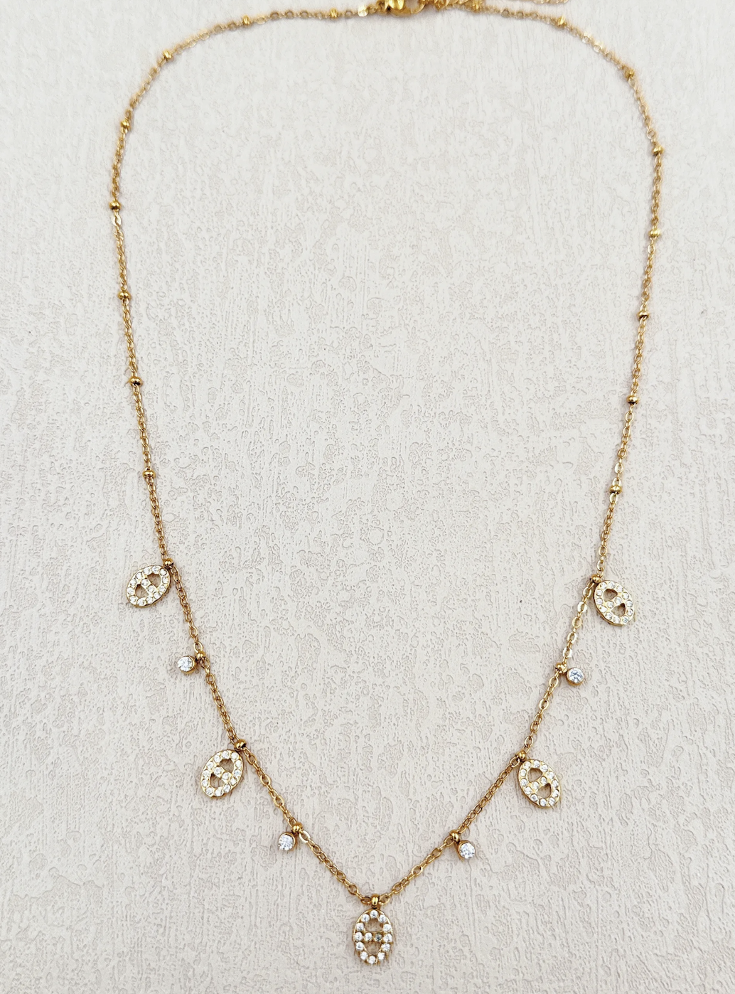 Collier Venezia : Cinq petites breloques ovales brillantes et détails ronds suspendus