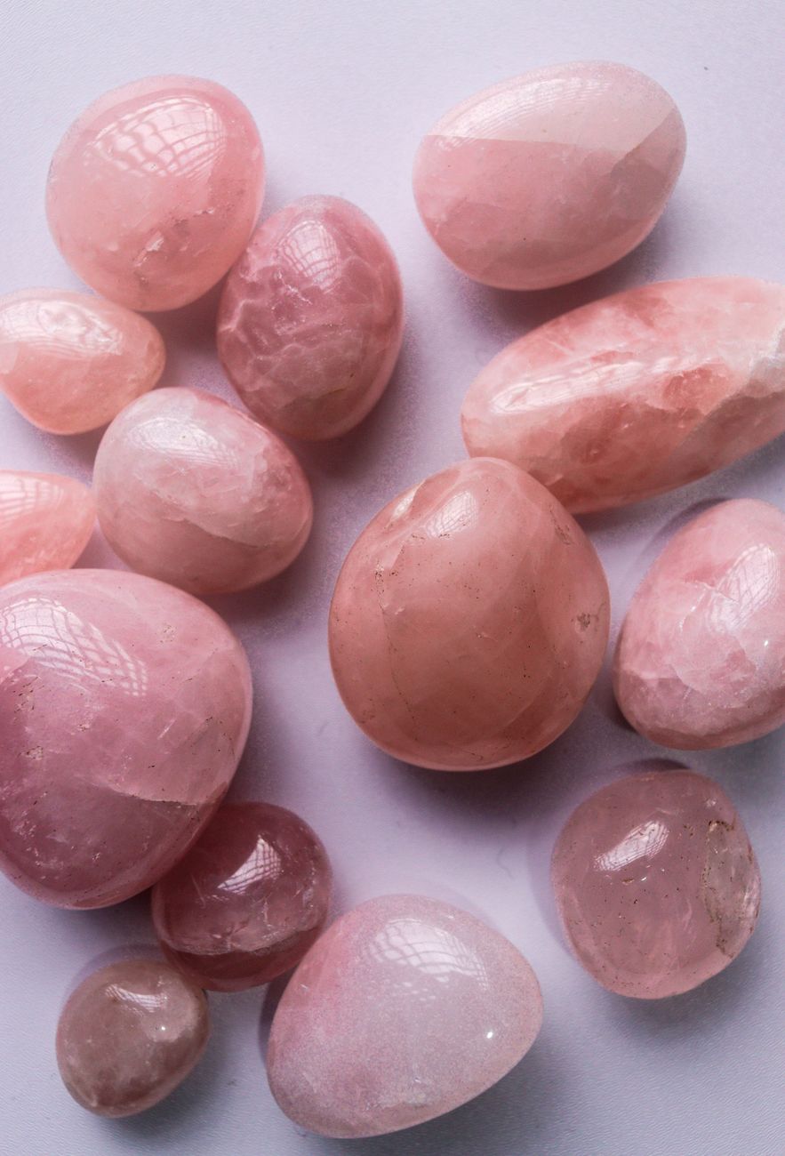 Gros plan sur des pierres de quartz rose polies, disposées sur une surface claire