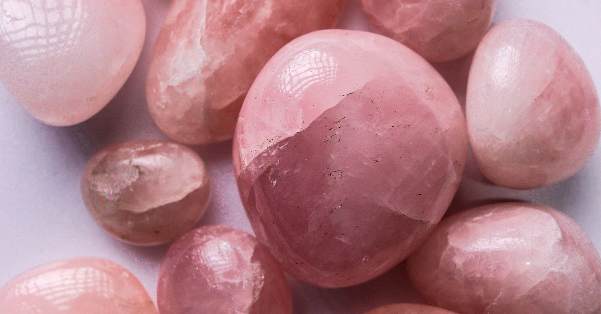 Une collection de pierres de quartz rose polies sur un fond clair, mettant en valeur leurs teintes roses