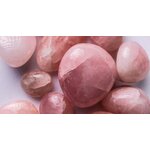 Une collection de pierres de quartz rose polies sur un fond clair, mettant en valeur leurs teintes roses