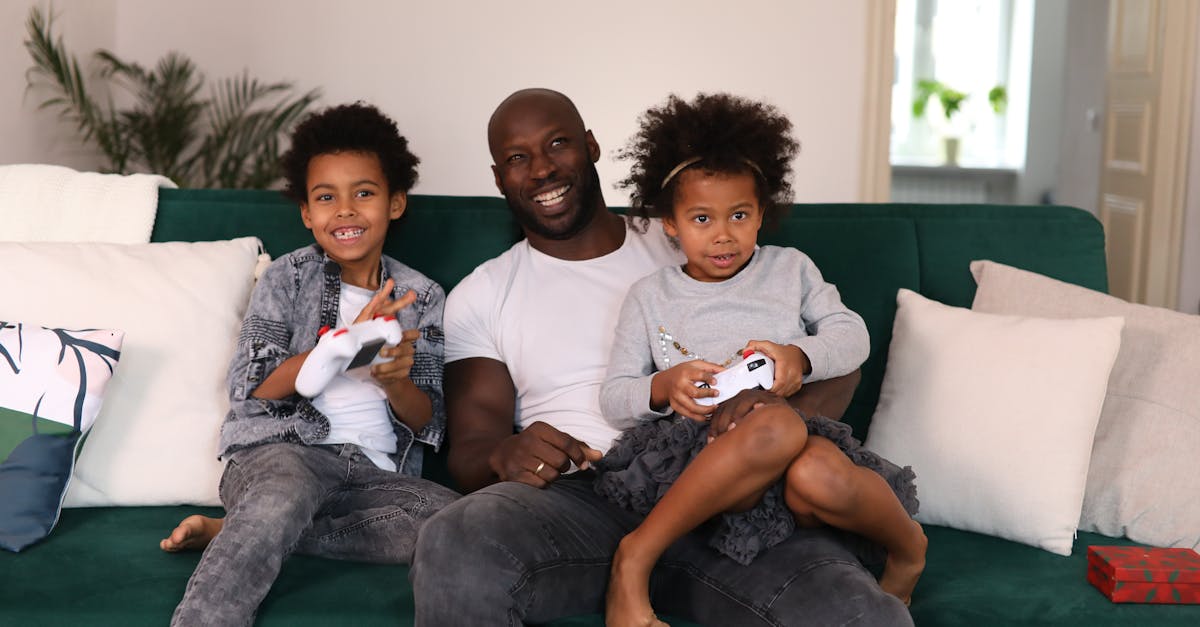 smiling father with children enjoying video games on a cozy living room sofa