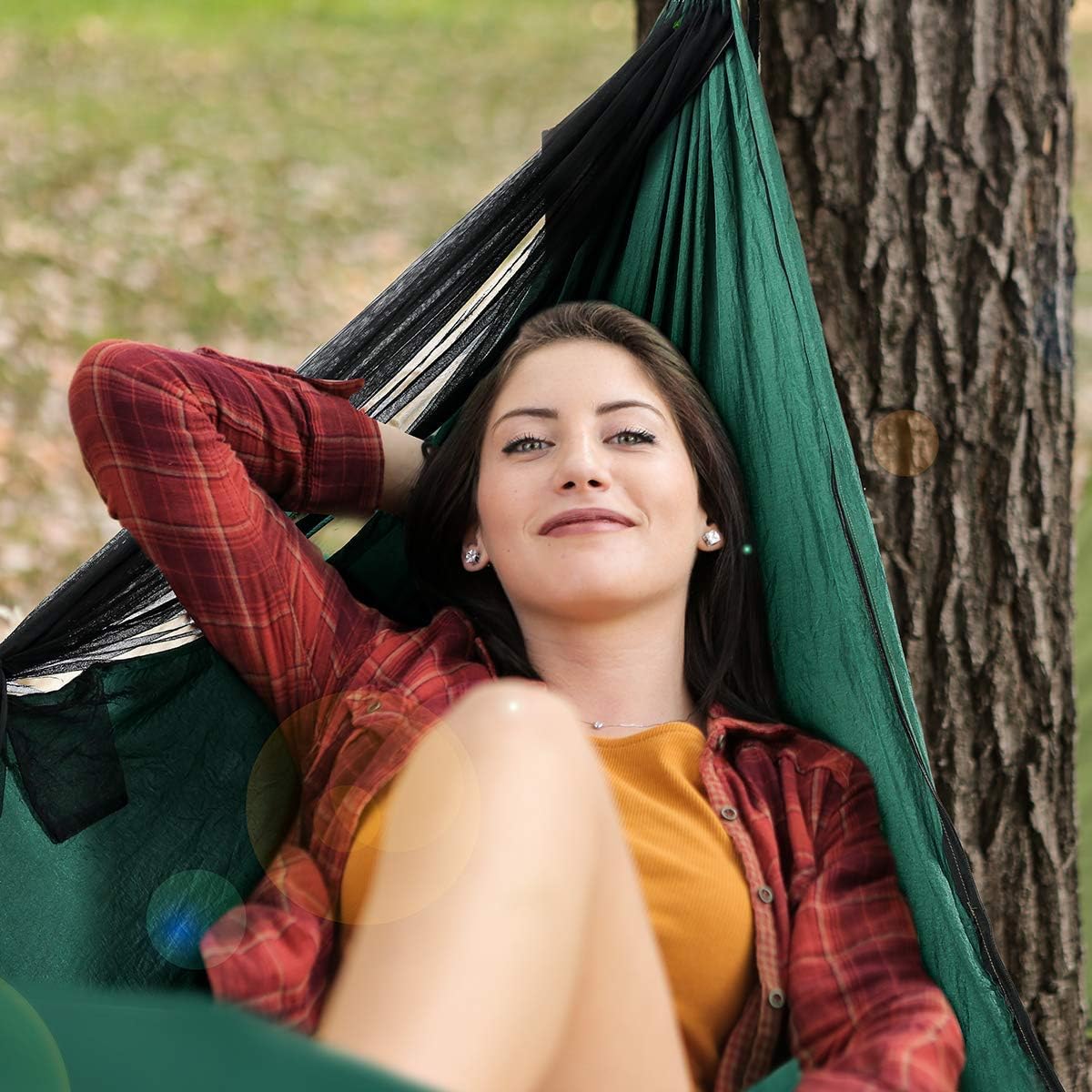 Woman relaxing outdoors in a dark green Covacure double hammock