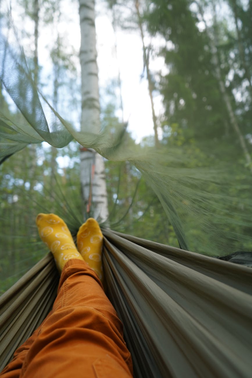 enjoying leisure time in a hammock under the forest canopy with legs stretched out