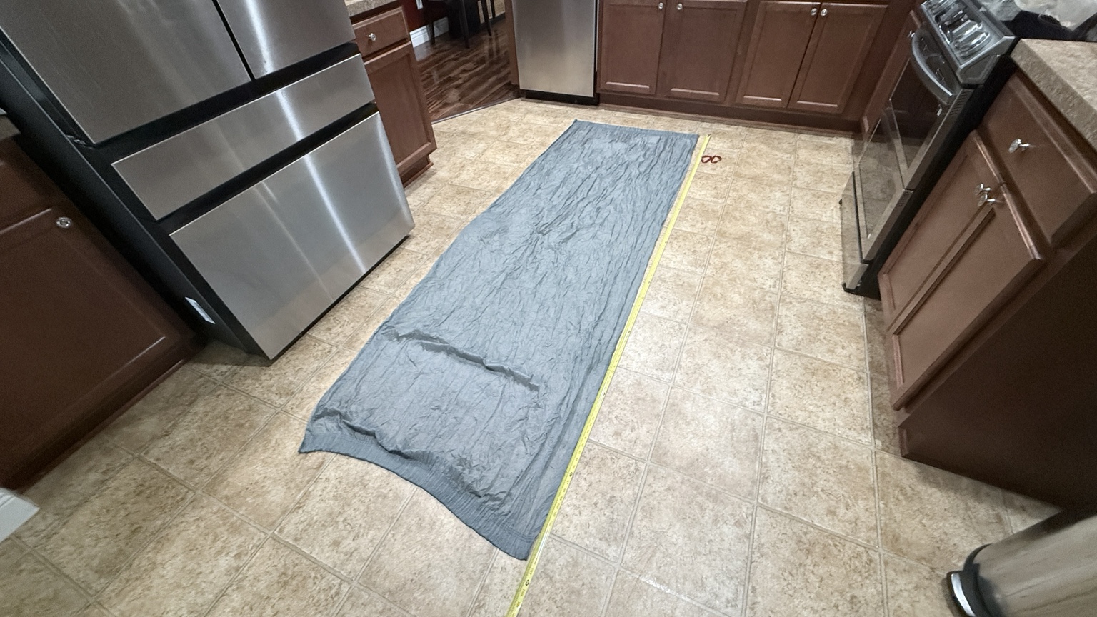 Mike’s gray Nano-7 laid flat on the floor beside a tape measure along its length.