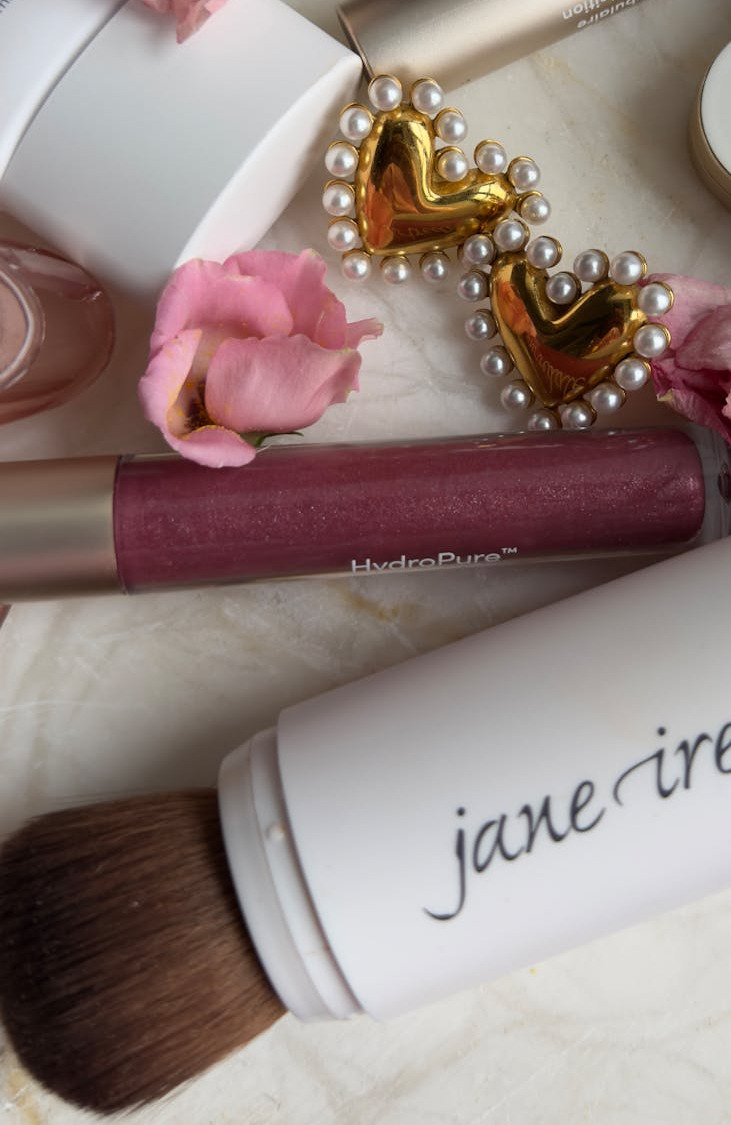 pose a plat de produits de beaute elegants et de fleurs avec accessoire coeur dore