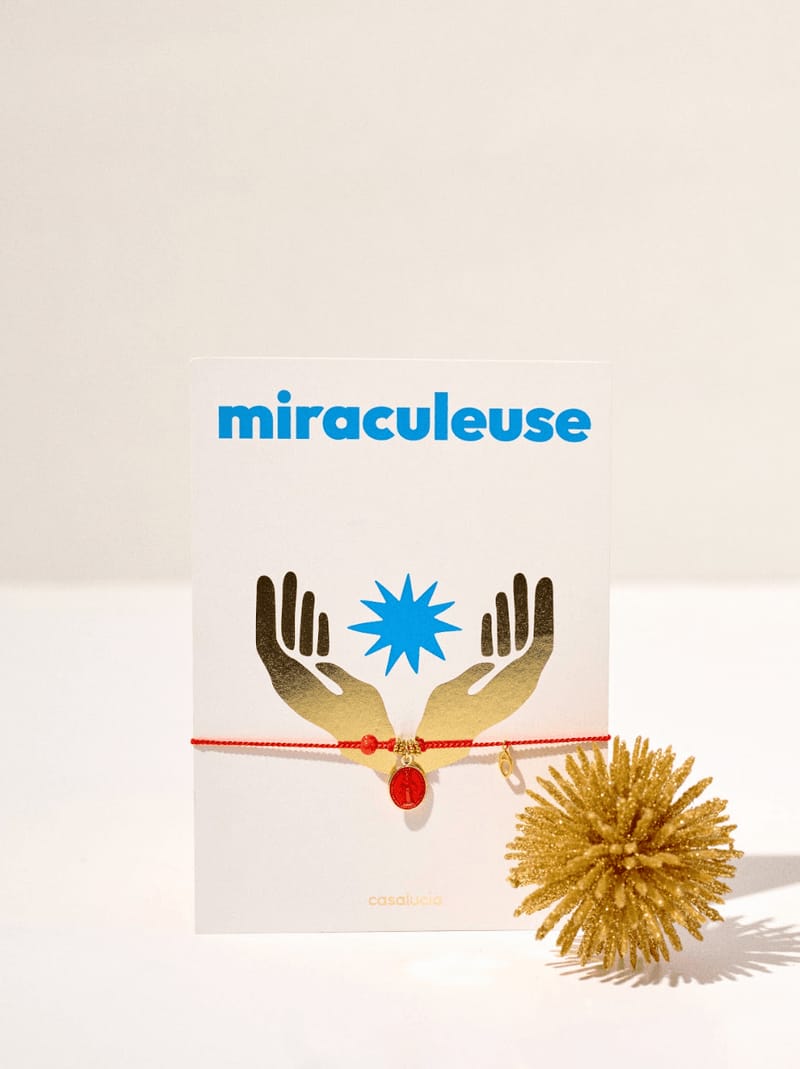 bracelet ornée d'une médaille en acier inoxydable recouverte de résine rouge avec une vierge et une perle de corail rouge naturel