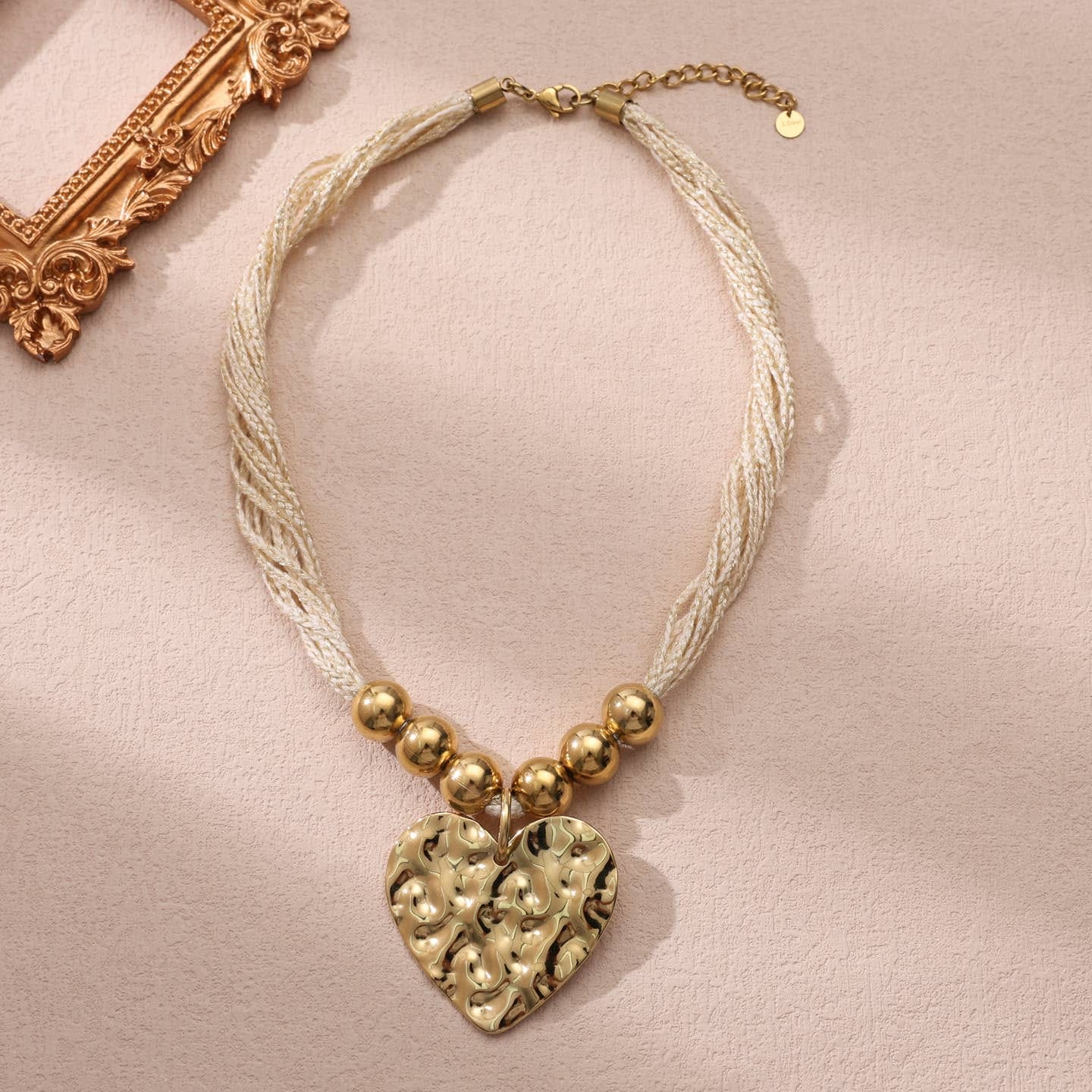 Collier multi cordons blanc avec un pendentif de cœur martelé