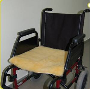 Plateau en peau de mouton médicalisée posé sur lassise dun fauteuil roulant