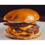 Gros plan dun cheeseburger juteux avec du bacon, du fromage et de la sauce sur un pain