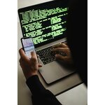Phone held in front of a computer displaying code