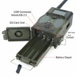 Open trail camera with battery compartment and ports