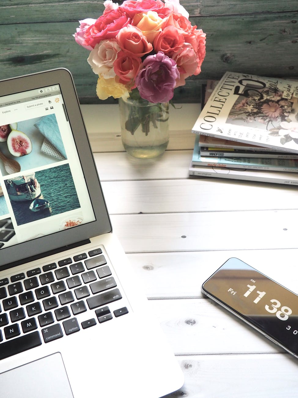macbook air bouquet de fleurs et magazines sur tableau blanc