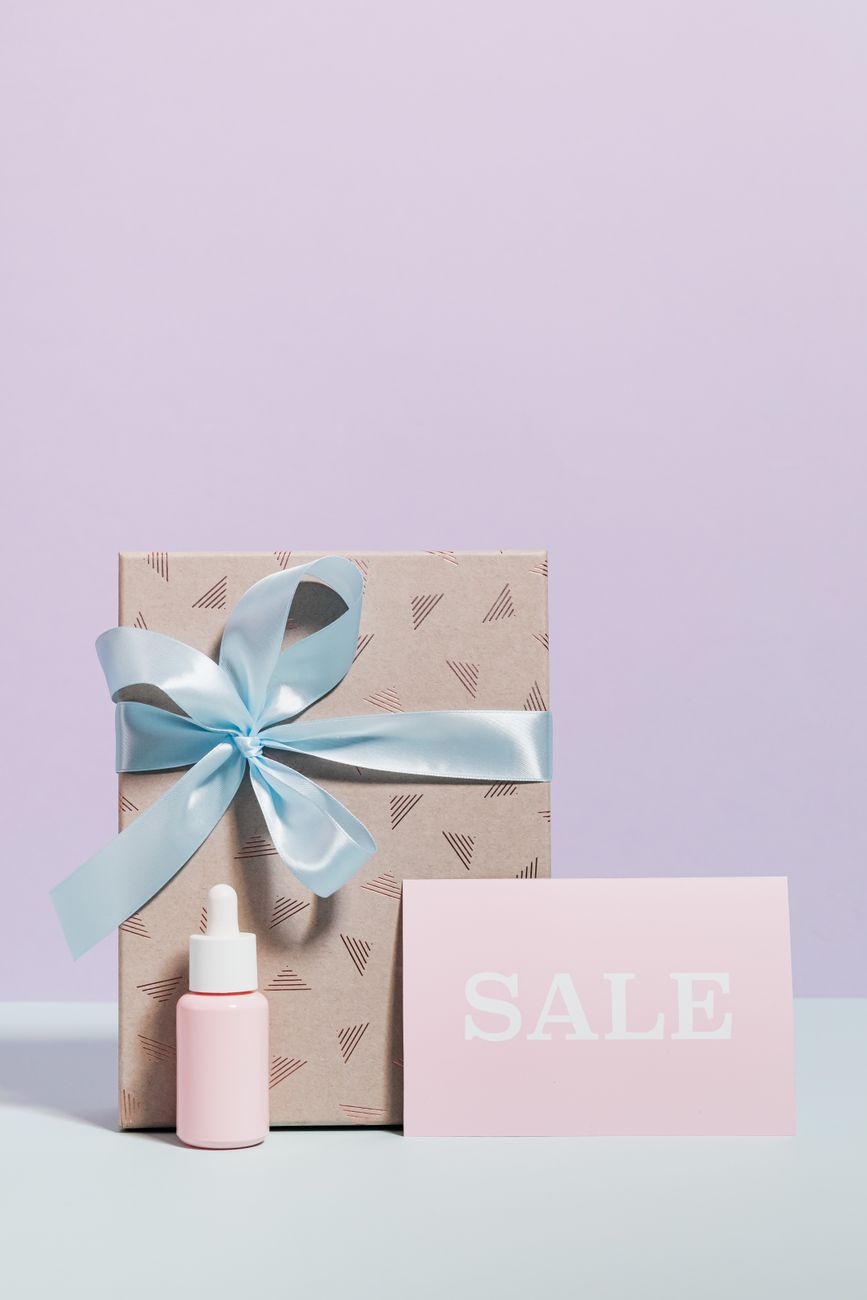 boite cadeau chic avec un ruban bleu et une carte de soldes sur un fond minimaliste