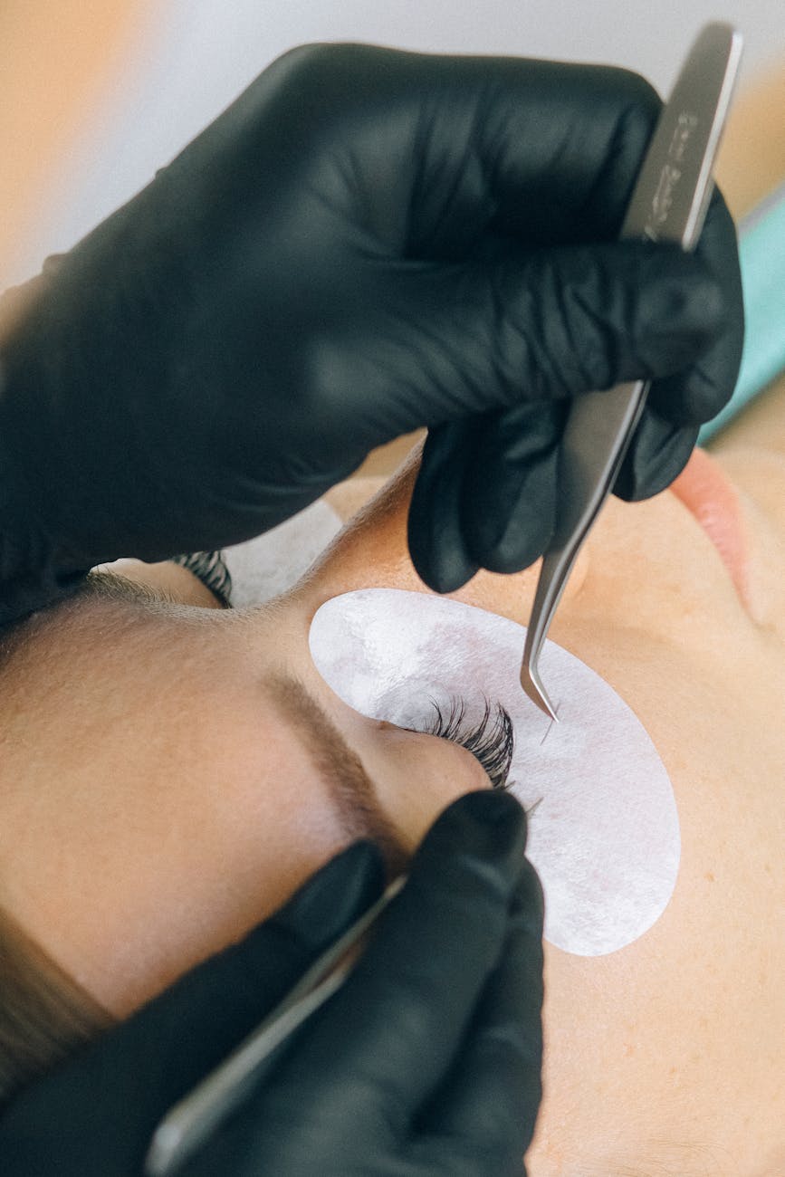 gros plan d une personne qui se fait poser des extensions de cils
