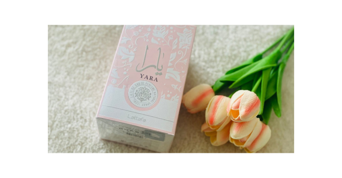 coffret de parfum yara aux cotes de tulipes roses posees sur un tapis moelleux mettant en valeur l elegance et la fraicheur