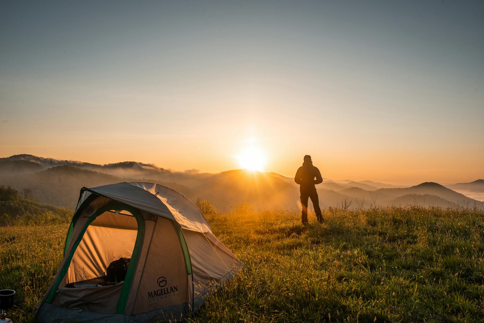 silhouette de personne debout pres de la tente de camping