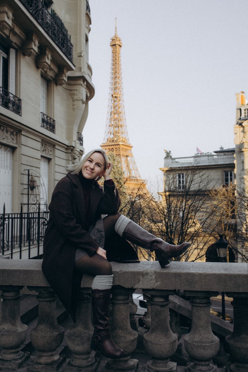femme souriante assise dans une tenue elegante avec la tour eiffel en arriere plan capturant le charme de paris