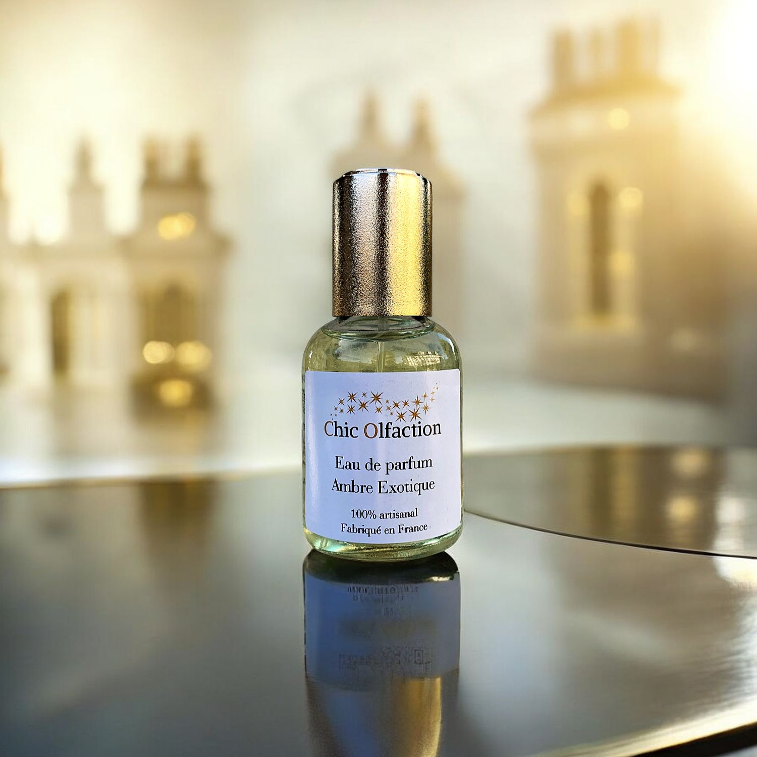 flacon deau de parfum de la marque chic olfaction posée sur une table noire derrière un décor doré  portant le nom dambre exotique