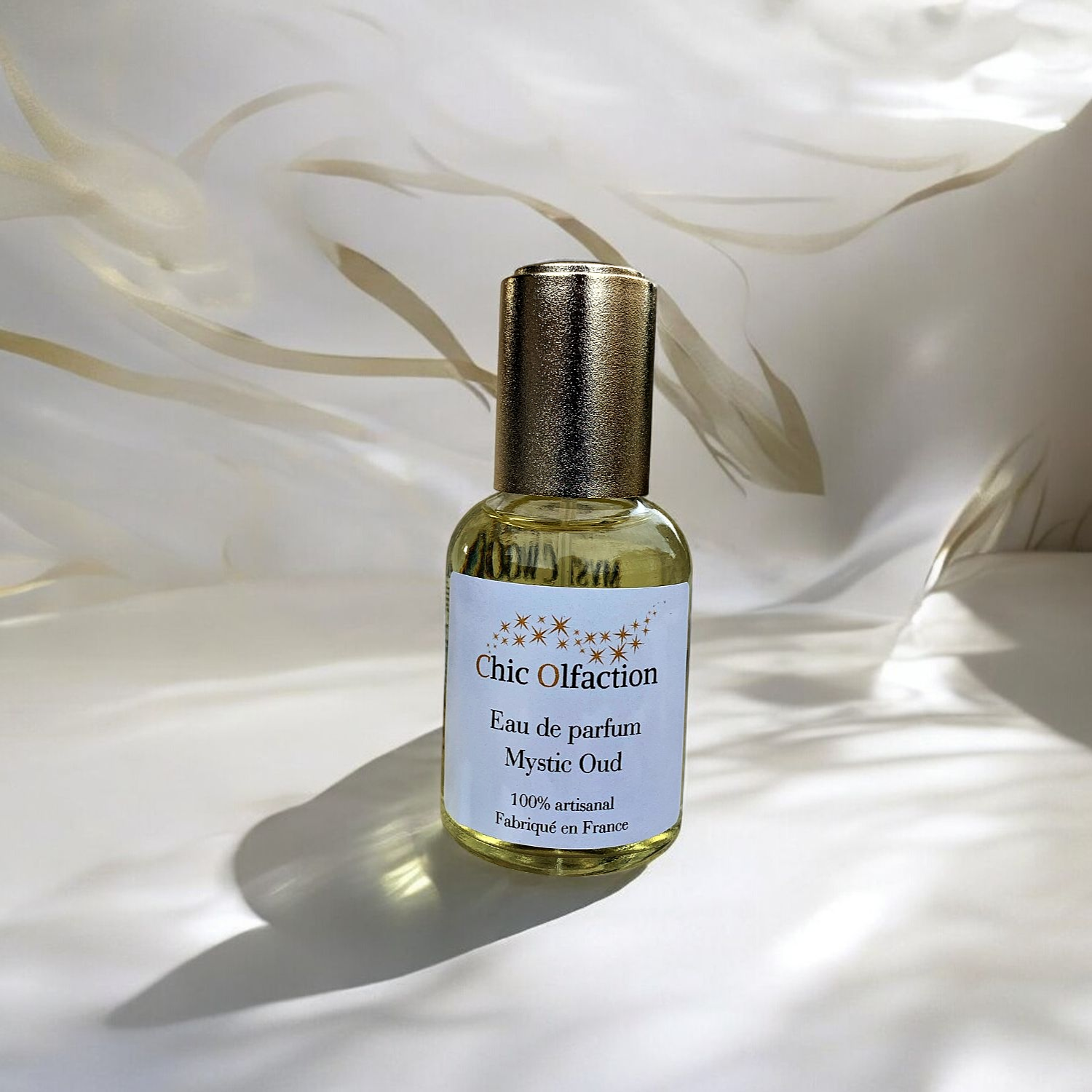 50 ml flacon eau de parfum au bois de oud de la marque chic olfaction posée sur des draps en soie blancs