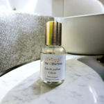 flacon d'eau de parfum de la marque chic olfaction portant le nom de céleste de la famille olfactive fleurie posé sur le plan de travail en marbre d'une salle de bains