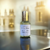 flacon d'eau de parfum de la marque chic olfaction posée sur une table noire derrière un décor doré  portant le nom d'ambre exotique