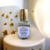 flacon d'eau de parfum de la marque chic olfaction portant le nom de poudré d'antan posé sur un tabouret beige avec un fond blanc étoilé