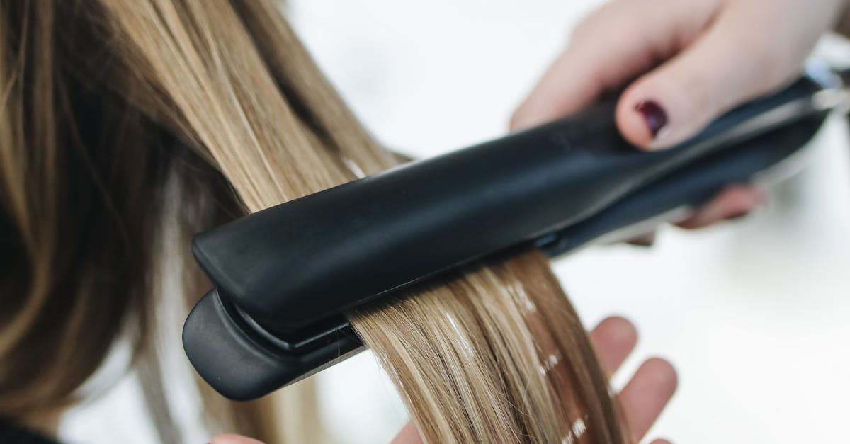personne repassant les cheveux d une femme