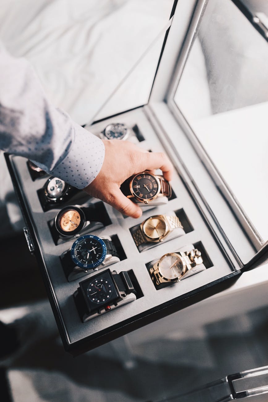 personne tenant une montre analogique ronde de couleur or avec bracelet a maillons