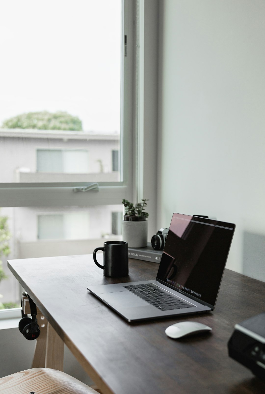Ordinateur portable avec souris et tasse près d’une fenêtre
