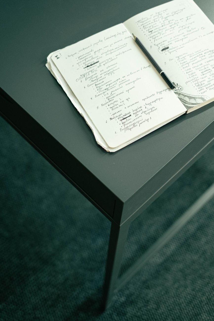 Carnet ouvert et crayon posés sur une table